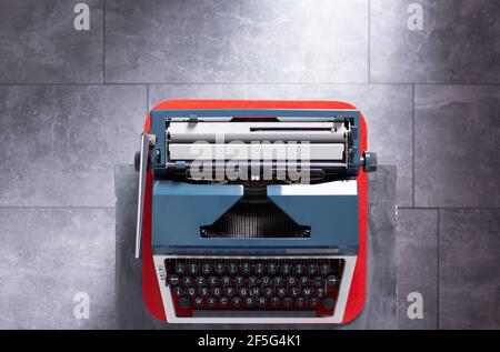 Macchina da scrivere vintage al tavolo superiore o scaffale sulla superficie di fondo del pavimento, sceneggiatore o concetto di scrittore retrò Foto Stock