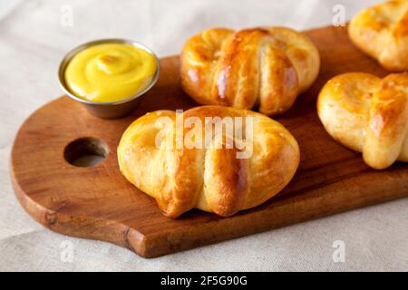 Soft Pretzel di base fatti in casa con senape, vista ad angolo basso. Primo piano. Foto Stock