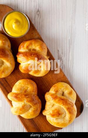 Pretzel morbidi di base fatti in casa con senape, vista dall'alto. Posa piatta, sovratesta, dall'alto. Spazio di copia. Foto Stock