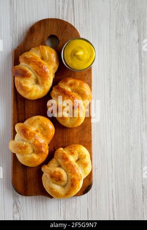 Pretzel morbidi di base fatti in casa con senape, vista dall'alto. Posa piatta, sovratesta, dall'alto. Spazio per il testo. Foto Stock