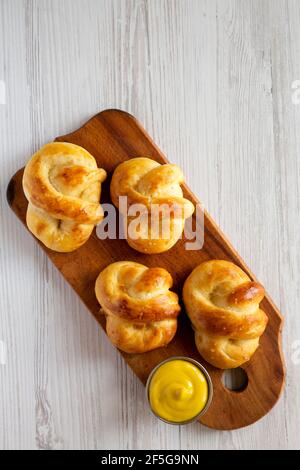 Pretzel morbidi di base fatti in casa con senape, vista dall'alto. Posa piatta, sovratesta, dall'alto. Spazio di copia. Foto Stock