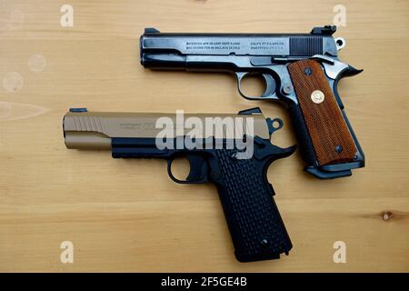 Un originale pistola automatica Colt 45 sopra una replica Colt 45 pistola automatica BB pistola Foto Stock