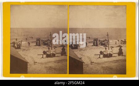 Spiaggia non identificata con persone, alcune con ombrelloni. Produttore sconosciuto, americano Foto Stock