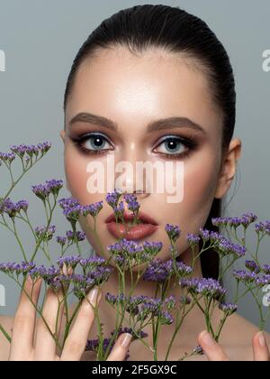 Ritratto di giovane donna bellissima con fiori Foto Stock