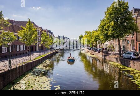 LEIDEN, PAESI BASSI - 27 GIUGNO 2018: Canali a Leiden, Paesi Bassi. Barca con persone sul canale il giorno d'estate. Foto Stock