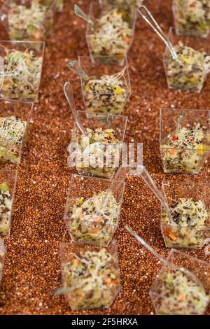 Elegante insalata di quinoa antipasti peruviani, antipasto, servito dalla compagnia di catering come antipasto in un contenitore di plastica trasparente portatile Foto Stock