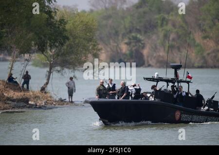 Granjeno, Texas USA, 26 marzo 2021. Con il Messico sullo sfondo, una delegazione di senatori repubblicani cavalcano sul Rio Grande River a sud della missione in un artigliere pesantemente armato del Texas Department of Public Safety. Durante il loro vorticoso tour del Texas meridionale, i 18 senatori hanno visto un centro di lavorazione dei migranti sovraffollato a Donna e un cadavere che galleggiava nel fiume a nord del Parco di Anzalduas. Credit: Bob Daemmrich/Alamy Live News Foto Stock