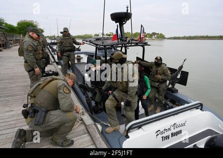 Granjeno, Texas USA, 26 marzo 2021. I soldati del Dipartimento della pubblica sicurezza del Texas aspettano che un gruppo di senatori repubblicani degli Stati Uniti salti a bordo della loro gunboat pesantemente armato per un giro sul Rio Grande River a sud di Mission alla fine di un vorticoso tour del Texas meridionale. I senatori videro un centro di lavorazione dei migranti sovraffollato a Donna e un cadavere che galleggiava nel fiume a nord del Parco di Anzalduas. Credit: Bob Daemmrich/Alamy Live News Foto Stock