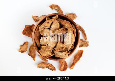 Fette di pere secche su sfondo bianco. Frutta secca sparsa su sfondo bianco. Pera tagliata candita. Vista dall'alto. Foto Stock