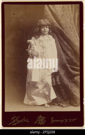 Burro di Ethel in abito da condimento bianco, che tiene un paio di scarpe e una bambola, in piedi. Philip S. Ryder (americano, attivo dal 1870 al 1920) Foto Stock