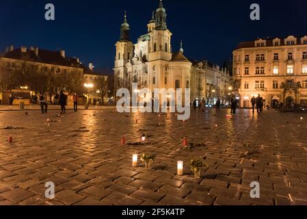 Praga, Repubblica Ceca. 26 Marzo 2021. Candele illuminate con fiori collocate su croci dipinte durante la commemorazione.quasi 25 migliaia di croci e nomi di covie 19 vittime sono temporaneamente dipinte nella Piazza della Città Vecchia di Praga per commemorare un anno anniversario della morte del primo covidio ceco 19 pazienti. (Foto di Tomas Tkacik/SOPA Images/Sipa USA) Credit: Sipa USA/Alamy Live News Foto Stock