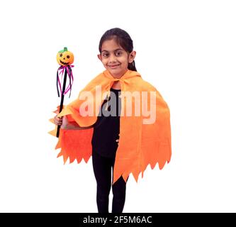 Carina bambina vestita in costume di zucca con una magia Bacchetta su sfondo bianco per Halloween Foto Stock