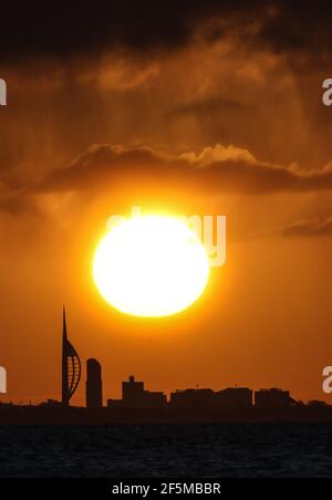 Portsmouth, Hampshire. 27 marzo 2021. Regno Unito Meteo. L'alba sulla Spinnaker Tower e lo skyline di Portsmouth sono raffigurati dall'altra parte del Solent in una luminosa mattinata soleggiata con occasionali docce. Credit Stuart Martin/Alamy Live News Foto Stock