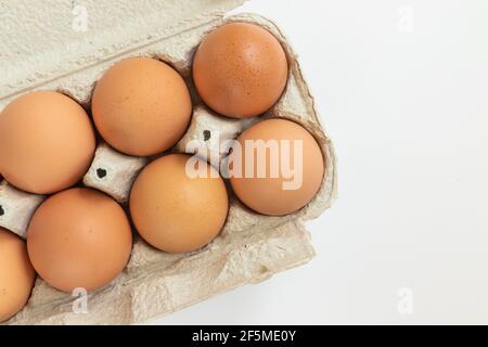 Uova di pollo isolate su sfondo bianco in un contenitore di cartone per il trasporto. Vista dall'alto. Foto Stock