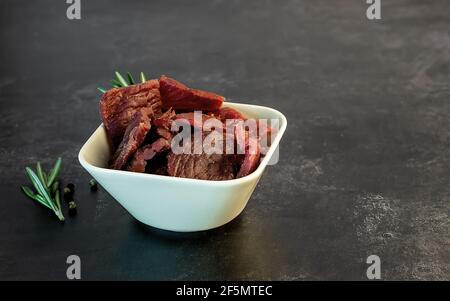 Spuntino a strappo di manzo ad alto contenuto proteico, carne magra. Affumicato, cibo secco. Foto Stock