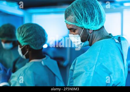 Medici che si preparano all'interno della sala operatoria chirurgica - lavoratori medici ottenere pronto per combattere contro la pandemia di coronavirus Foto Stock