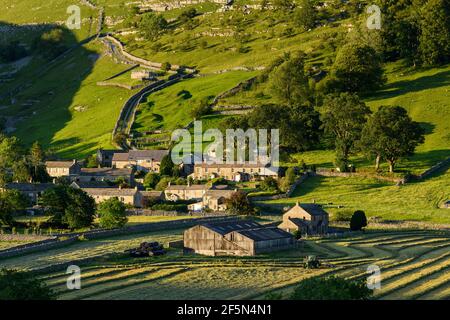 Pittoresca valle Dales & piccolo villaggio, case, fienile, campi agricoli, collina, Collina ripida e trattore fieno-fare - Starbotton, Yorkshire, Inghilterra Regno Unito. Foto Stock