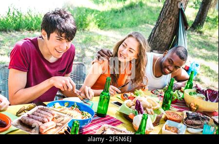 Felice gente che si diverte insieme al barbecue picnic party - Giovani amici multirazziali alla riunione sociale pic nic - Gioventù concetto di stile di vita Foto Stock