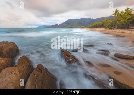 Litorale roccioso su un idilliaco, tropicale spiaggia di Thala vicino a Oak Beach all'alba o al tramonto fuori Port Douglas e il Daintree in Queensland, Aus Foto Stock