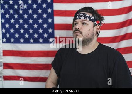 Maschio caucasico in piedi davanti alla bandiera americana Foto Stock