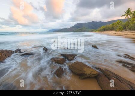 Litorale roccioso su un idilliaco, tropicale spiaggia di Thala vicino a Oak Beach all'alba o al tramonto fuori Port Douglas e il Daintree in Queensland, Aus Foto Stock