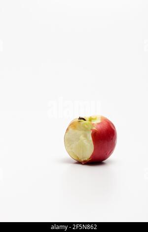 Una mela rossa matura isolata su uno sfondo bianco. Mela rossa morso su sfondo bianco. Percorso di ritaglio Apple. Foto verticale una mela. Foto Stock