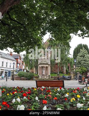 La statua della Regina Anna in Wellington Square, Minehead. Posti a sedere per coloro che desiderano riposare. Un paio di visitatori lo hanno usato per riposare le loro moto Foto Stock