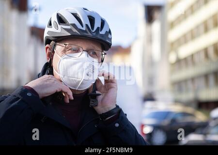 27 marzo 2021, Turingia, Erfurt: Bodo Ramelow (sinistra), Presidente del Ministro della Turingia, mette su un casco da bicicletta per un tour in bicicletta attraverso le pianure alluvionali di Gera. In vista del prossimo Salone Federale dell'Orticoltura di Erfurt, i lavori sono in pieno svolgimento lungo i prati fluviali della Gera, al di fuori delle aree espositive. Secondo la città, il più grande parco paesaggistico contiguo della Turingia è stato creato su un'area di circa 65 ettari a nord della capitale dello stato. Le aree principali del Federal Horticultural Show, che sarà aperto il 23 aprile, sono Egapark e Petersberg, a per Foto Stock