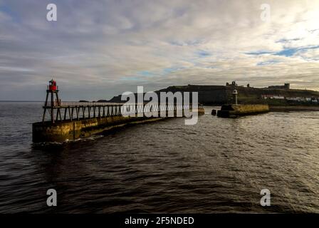 Moli e fari a Whitby Harbour, North Yorkshire, Regno Unito in inverno Foto Stock