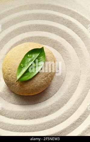 Sabbia, cerchi e pietra. Foglia verde. Concetto di spa. Foto Stock