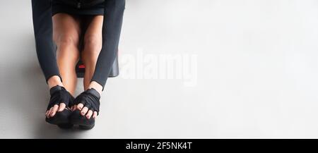 close up piedi di una ragazza che fa l'allenamento sul pavimento palestra con guanti e calze con un lungo e. sfondo bianco esteso orizzontale Foto Stock