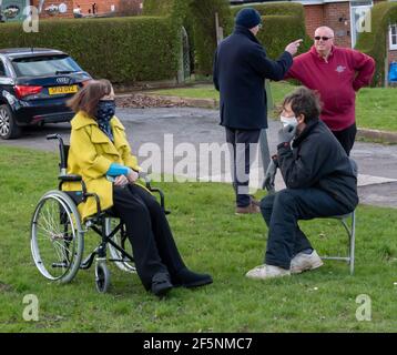 Brentwood Essex 27 marzo 2021 elezioni del Consiglio locale; la Consigliera liberaldemocratico Karen Chilvers (raffigurata in giallo in sedia a rotelle) sulla sua campagna "Wheels on the Green" a Brentwood Essex. Credit: Ian Davidson/Alamy Live News Foto Stock