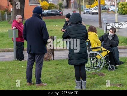 Brentwood Essex 27 marzo 2021 elezioni del Consiglio locale; la Consigliera liberaldemocratico Karen Chilvers (raffigurata in giallo in sedia a rotelle) sulla sua campagna "Wheels on the Green" a Brentwood Essex. Credit: Ian Davidson/Alamy Live News Foto Stock