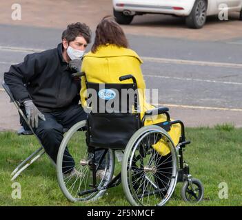 Brentwood Essex 27 marzo 2021 elezioni del Consiglio locale; la Consigliera liberaldemocratico Karen Chilvers (raffigurata in giallo in sedia a rotelle) sulla sua campagna "Wheels on the Green" a Brentwood Essex. Credit: Ian Davidson/Alamy Live News Foto Stock