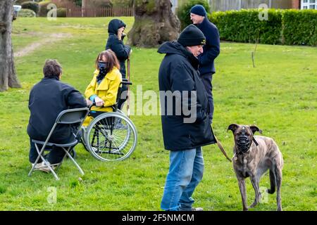 Brentwood Essex 27 marzo 2021 elezioni del Consiglio locale; la Consigliera liberaldemocratico Karen Chilvers (raffigurata in giallo in sedia a rotelle) sulla sua campagna "Wheels on the Green" a Brentwood Essex. Credit: Ian Davidson/Alamy Live News Foto Stock