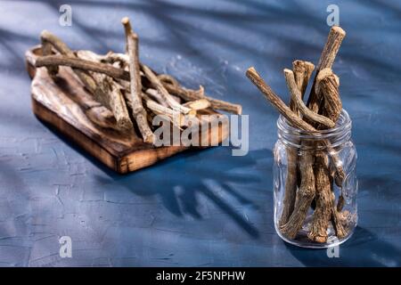 Steli secchi di valeriano medicinale su fondo di legno - Valeriana officinalis Foto Stock