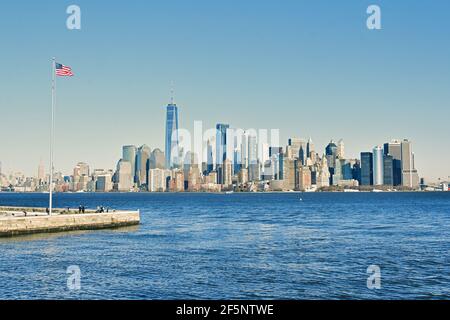 Edifici architettura di Manhattan e bandiera americana visto da una crociera in traghetto sul fiume Hudson, New York City, USA. Foto Stock