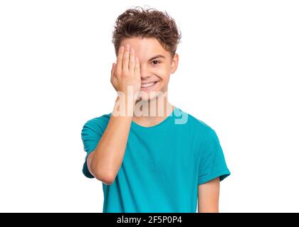 Bel ragazzo si guarda con un occhio mentre gli copre l'altro occhio con la mano, isolato su sfondo bianco Foto Stock