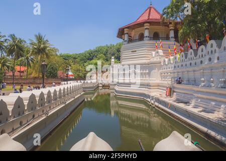 Kandy, Sri Lanka - Marzo 20 2019: Le bandiere buddiste e l'acqua si presentano in una giornata di sole al di fuori del Tempio della Reliquia del Sacro dente a Kandy, Sri LAN Foto Stock