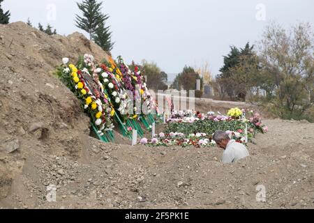 STEPANAKERT, NAGORNO KARABAKH - NOVEMBRE 05: Uomo che scavava tombe per i militari di etnia armena uccisi durante gli scontri con le truppe azerbaigiane il 05 novembre 2020, a Stepanakert, Nagorno-Karabakh. I combattimenti tra Armenia e Azerbaigian sul Nagorno-Karabakh nella proclamata Repubblica di Artsakh, parte de jure della Repubblica di Azerbaigian, sono riesplose alla fine di settembre in una guerra di sei settimane con entrambi i paesi accusandosi a vicenda di provocazioni che hanno lasciato migliaia di morti. Foto Stock