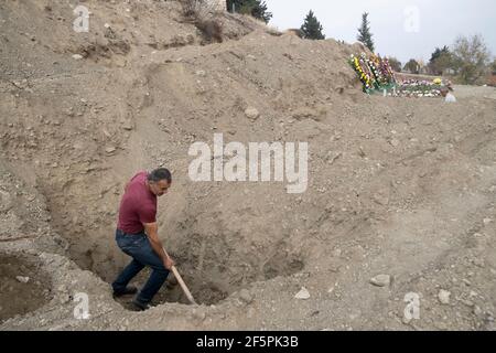 STEPANAKERT, NAGORNO KARABAKH - NOVEMBRE 05: Gravedigger Martin Ghulyan scavando tombe per i militari di etnia armena uccisi durante gli scontri con le truppe azerbaigiane in un cimitero militare il 05 novembre 2020, in Stepanakert, Nagorno-Karabakh. I combattimenti tra Armenia e Azerbaigian sul Nagorno-Karabakh nella proclamata Repubblica di Artsakh, parte de jure della Repubblica di Azerbaigian, sono riesplose alla fine di settembre in una guerra di sei settimane con entrambi i paesi accusandosi a vicenda di provocazioni che hanno lasciato migliaia di morti. Foto Stock