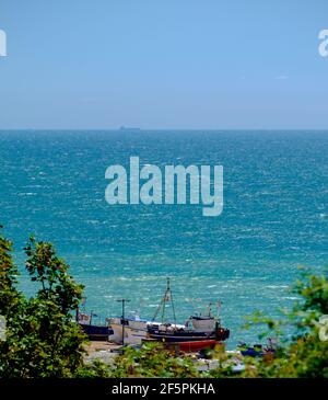 Idea di staycation. Vista elevata del canale Inglese allo Stade, Hastings, con barche da pesca da spiaggia. East Sussex, Inghilterra, Regno Unito. Foto Stock