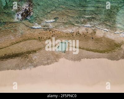 Spiaggia sabbiosa e rocciosa di fondo foto aerea. Sabbia bianca, acque turchesi cristal e barriera corallina Foto Stock