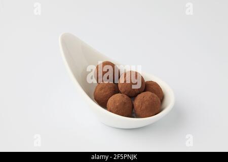 tartufi di cioccolato su piatto su sfondo bianco Foto Stock