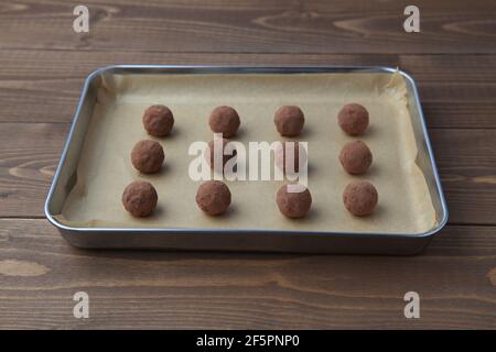 tartufi di cioccolato su piastra d'argento su tavola di legno Foto Stock