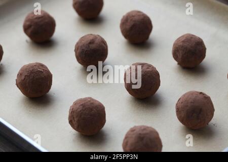 tartufi di cioccolato su piastra d'argento su tavola di legno Foto Stock