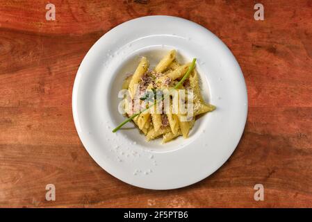 penne con salsa di carne e timo alla salsiccia. Maccheroni Pasta italiana in piatto bianco su tavola di legno, vista dall'alto, piatto Foto Stock