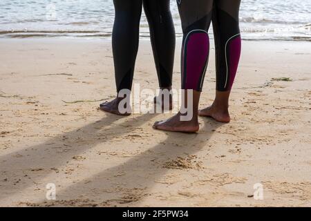 Primo piano di piedi con due donne vestite mute Foto Stock