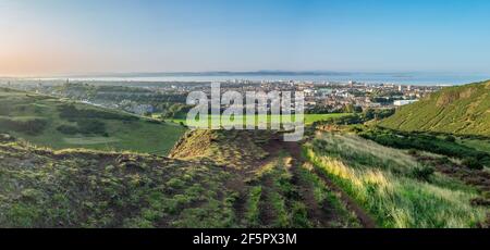 Panorama di Edimburgo, Scozia, tra cui Holyrood Palace e Calton Hill, come preso da Arthur's Seat in UNA bella, chiara serata estiva Foto Stock