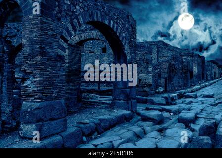 Pompei di notte, Italia. Vista apocalittica mistica di case distrutte della città antica in piena luna. Scena oscura spooky per il tema di Halloween. Concetto di h Foto Stock